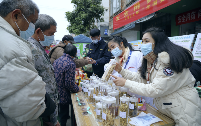 圖為工作人員現(xiàn)場向群眾講解常用中藥材的鑒別知識，普及藥品安全相關(guān)法律法規(guī)。