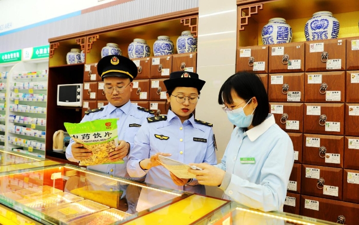 圖為4月25日，執(zhí)法人員在對(duì)一家零售藥店的中藥飲片進(jìn)行檢查。
