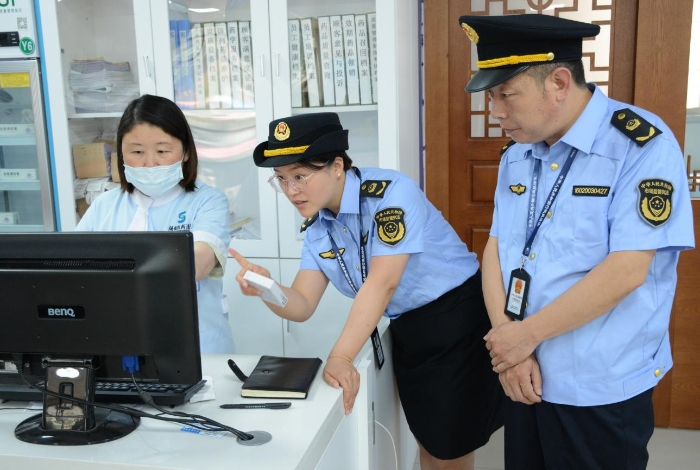 圖為6月19日執(zhí)法人員在一家藥品零售企業(yè)門店檢查含特殊藥品復方制劑的“進銷存”情況和購買此類藥品顧客的人員信息登記情況。