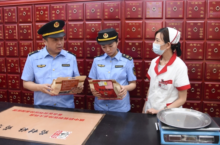 圖為執(zhí)法人員正在一家藥品經(jīng)營企業(yè)抽檢中藥飲片。