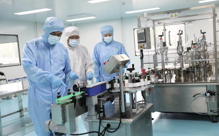 圖為執(zhí)法人員在一家醫(yī)療器械生產(chǎn)企業(yè)查看生產(chǎn)線情況。