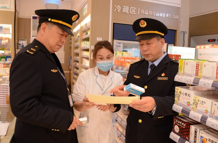 圖為執(zhí)法人員在一家藥品經(jīng)營企業(yè)檢查抗病毒藥品的購進情況。