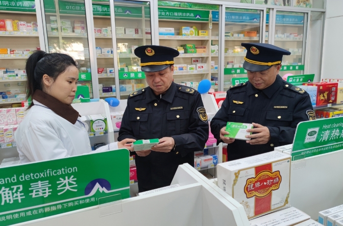 圖為執(zhí)法人員在藥店檢查抗病毒類藥品質(zhì)量情況。
