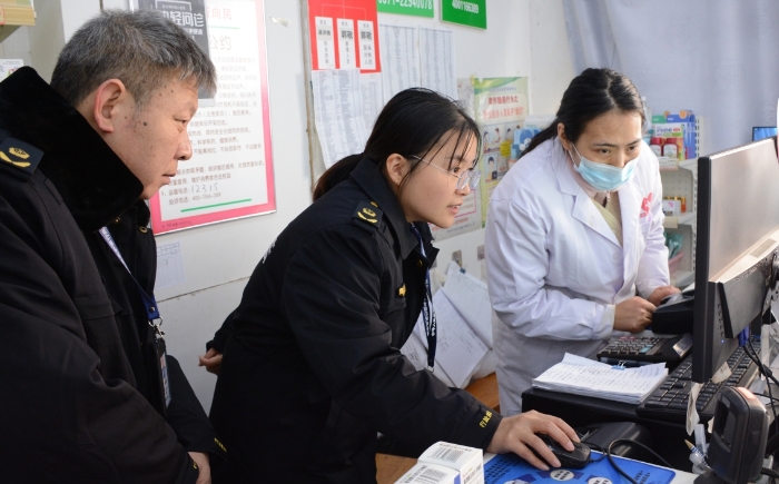 圖為執(zhí)法人員正在檢查藥品網(wǎng)絡(luò)銷售情況。