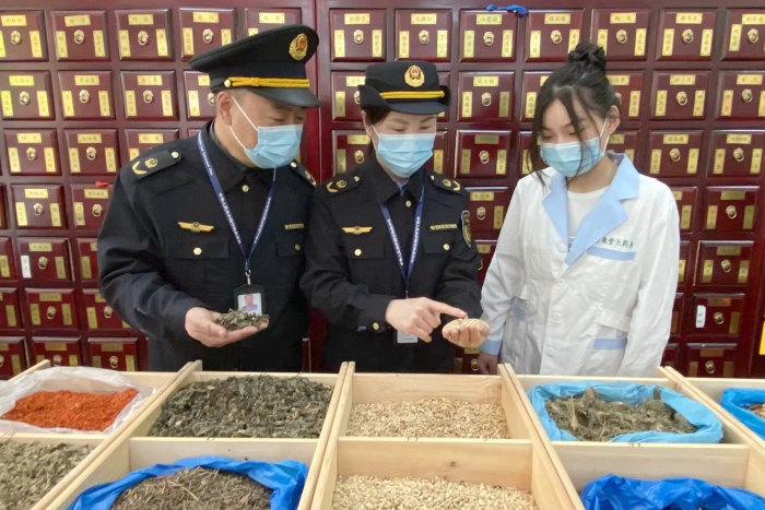 圖為執(zhí)法人員檢查中藥飲片。