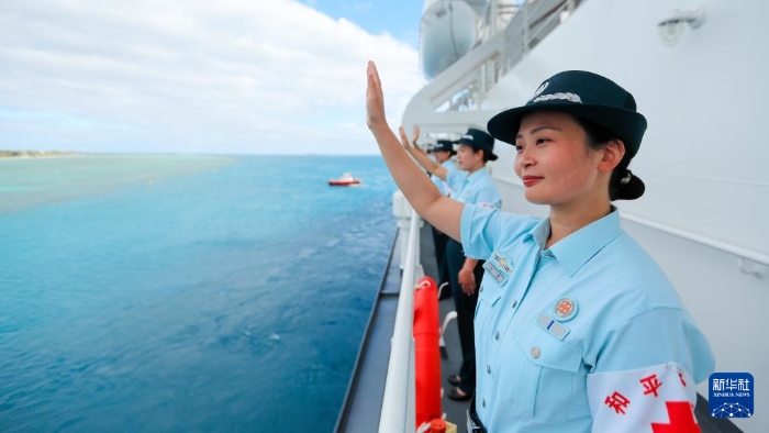 中國(guó)海軍“和平方舟”號(hào)醫(yī)院船結(jié)束訪問(wèn)湯加時(shí)，任務(wù)官兵中的文職人員向歡送人群揮手告別（2023年8月4日攝）。新華社發(fā)（徐巍 攝）