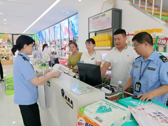 圖為執(zhí)法人員在一家商場發(fā)放宣傳材料。