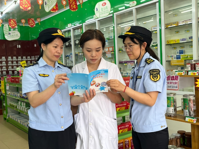 圖為8月28日，該局執(zhí)法人員會同上思縣市場監(jiān)管局在一家藥店向從業(yè)人員派發(fā)宣傳資料。（廖開軍 凌莉萍 攝）