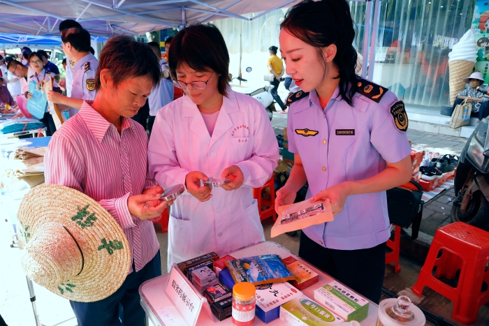 工作人員為群眾講解如何識(shí)別假冒偽劣藥品。（何正君攝）
