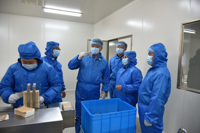 圖為甘肅省藥監(jiān)局黨組書記、局長吉永鋒（右四）帶領(lǐng)調(diào)研組在白銀振亞衛(wèi)生材料有限公司查看祖師麻關(guān)節(jié)止痛膏生產(chǎn)情況 。 （盧昌貴 攝）