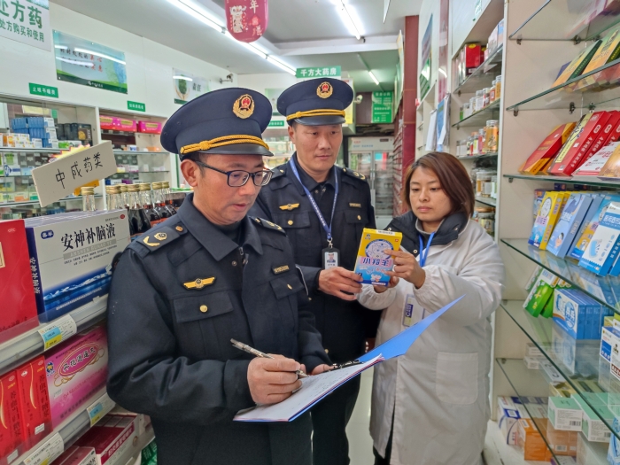 圖為近日，該局執(zhí)法人員在一家零售藥店檢查退熱貼標簽標識。（鄢國卿 攝）