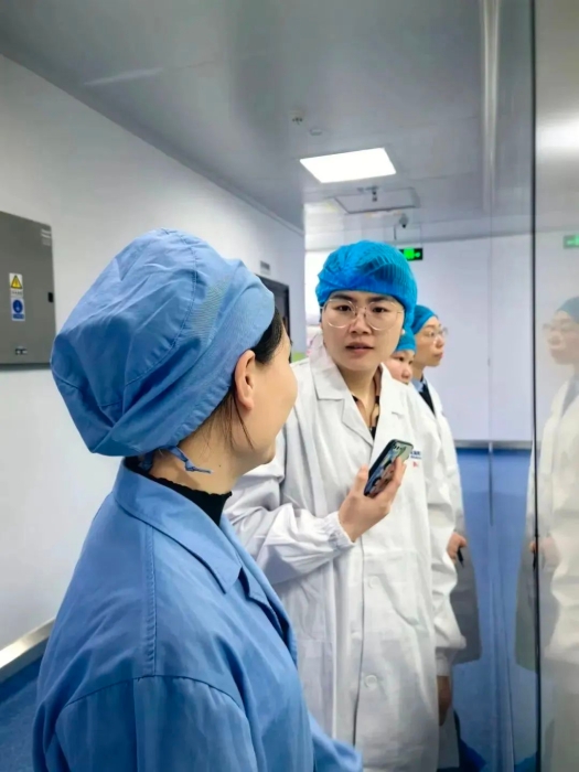 1月24日，中國醫(yī)藥報記者蔣紅瑜（右一）在桂林南藥生產(chǎn)車間采訪抗瘧藥品生產(chǎn)線改造情況