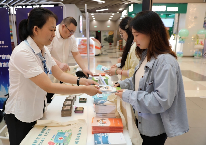 圖為工作人員向市民發(fā)放《藥品管理法實(shí)施條例》解讀以及用藥安全科普知識(shí)宣傳手冊(cè)。（葉陽(yáng)歡攝）
